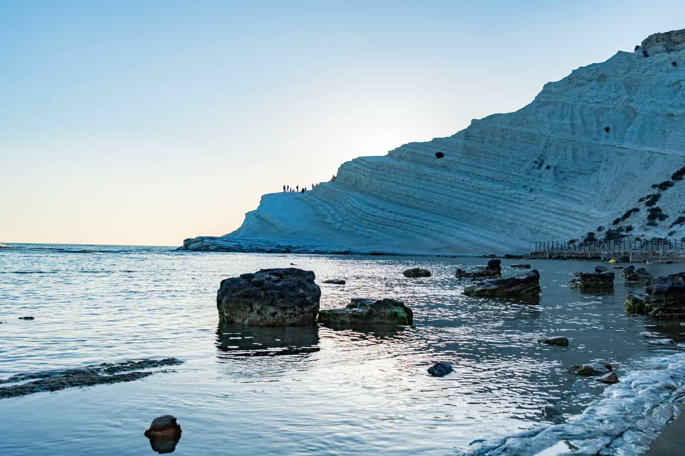 Die weißen Kalksteinfelsen der Scala dei Turchi erheben sich steil aus dem ruhigen Meer.