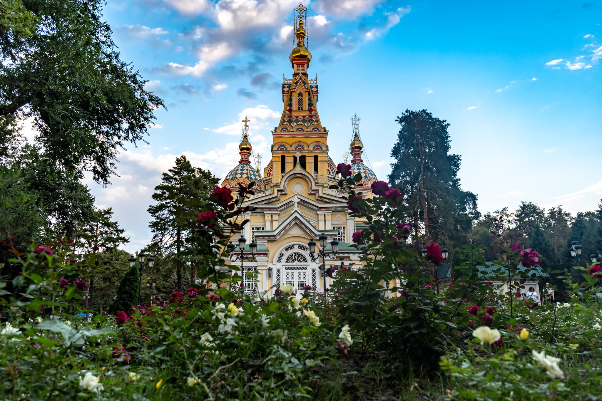 Almaty Sehenswürdigkeiten: Die schönsten Highlights & meine 8 Tipps 19 Christi-Himmelfahrt-Kathedrale in Almaty, im Vordergrund blühende rote, rosa und weiße Rosen